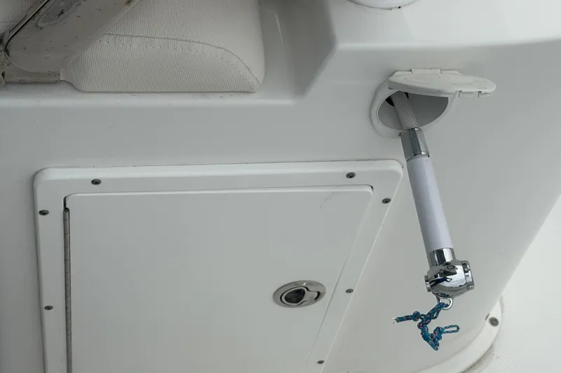 Slide: The Image of 2025 Sea Hunt Gamefish 25 boat detail showing a retractable hose and storage compartment. - 44