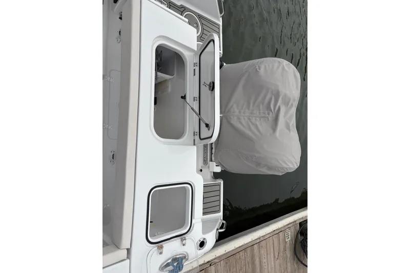Slide: The Image of 2025 Sea Hunt Gamefish 25 boat with covered engine and open storage compartments. - 46