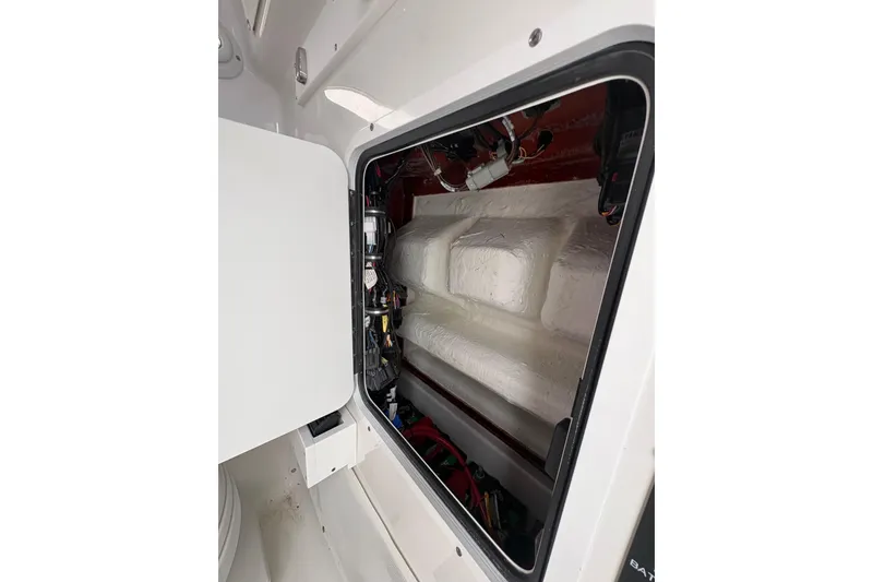 Slide: The Image of Interior view of 2025 Sea Hunt Gamefish 25 boat compartment with wiring and storage space. - 47