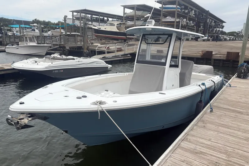 Slide: The Image of 2025 Sea Hunt Gamefish 25 boat docked at marina, featuring sleek design and spacious deck. - 5
