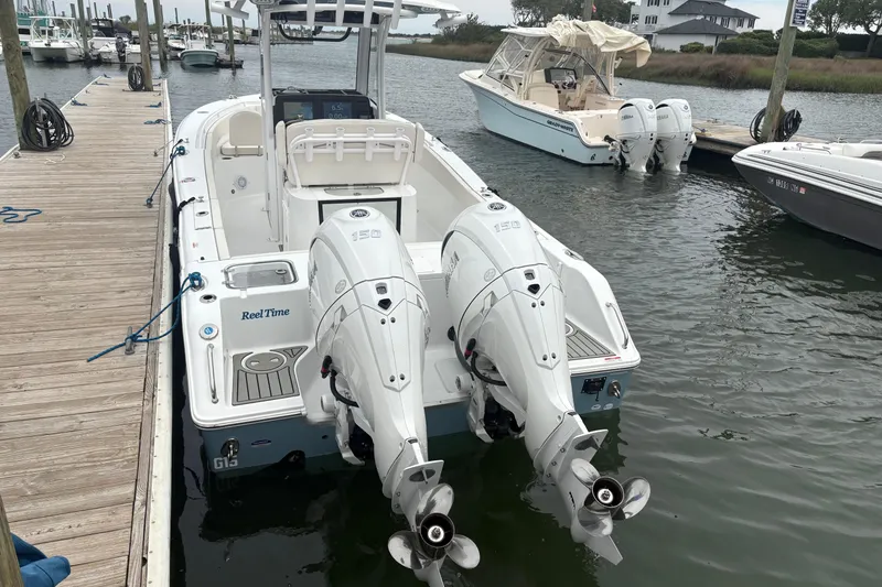 Slide: The Image of 2025 Sea Hunt Gamefish 25 boat docked with twin outboard engines. - 7