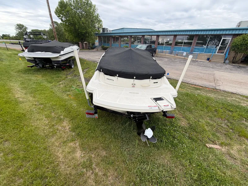 Slide: The Image of 2010 Sea Ray 185 SP/SS boat covered and parked on grass. - 3