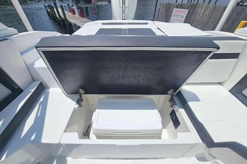 Slide: The Image of 2024 Monterey 215SS Super Sport boat with open storage compartment and cooler. - 17