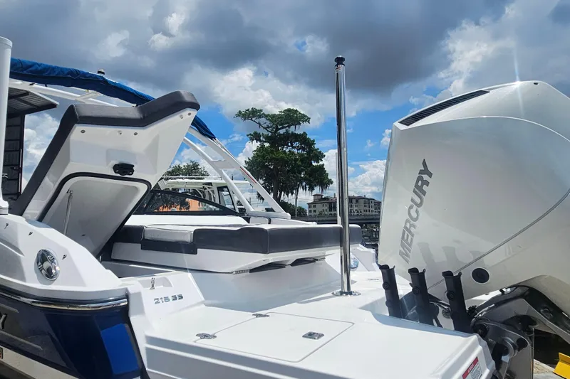 Slide: The Image of 2024 Monterey 215SS Super Sport boat with Mercury engine, docked under a cloudy sky. - 24