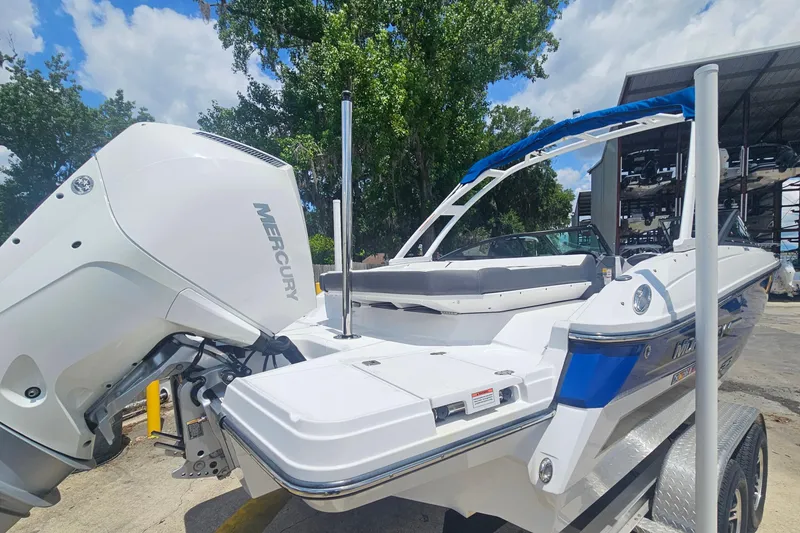 Slide: The Image of 2024 Monterey 215SS Super Sport boat with Mercury engine, parked outdoors on a sunny day. - 5