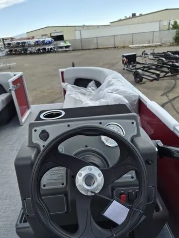 Slide: The Image of 2026 Sun Tracker Party Barge 16 DLX steering console in parking lot. - 13