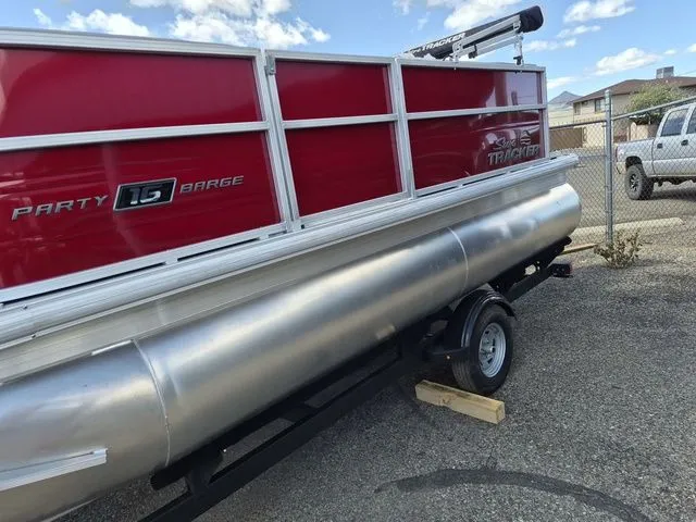 Slide: The Image of Sun Tracker Party Barge 16 DLX 2026 on trailer, red siding. - 7