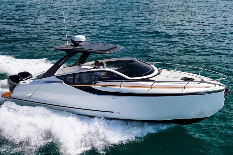 Slide: The Image of 2023 Fairline F//Line 33 Outboard cruising on ocean near coastal cityscape. - 1