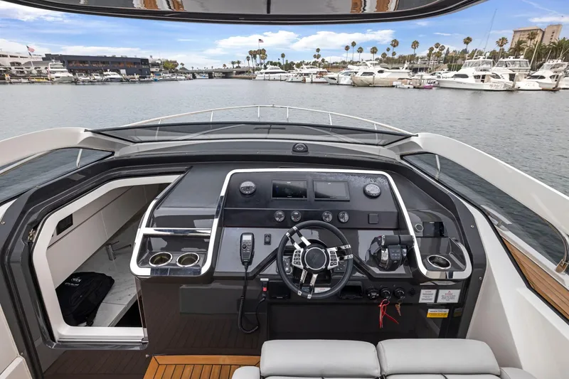 Slide: The Image of 2023 Fairline F//Line 33 Outboard yacht cockpit with modern controls, docked in a marina. - 36