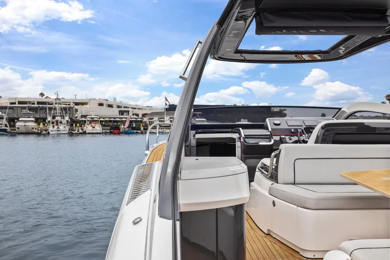 Slide: The Image of 2023 Fairline F//Line 33 Outboard yacht interior with marina view, featuring sleek design and luxury seating. - 46
