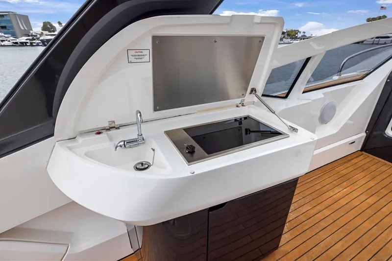Slide: The Image of 2023 Fairline F//Line 33 Outboard yacht kitchenette with sink and stove on deck. - 50