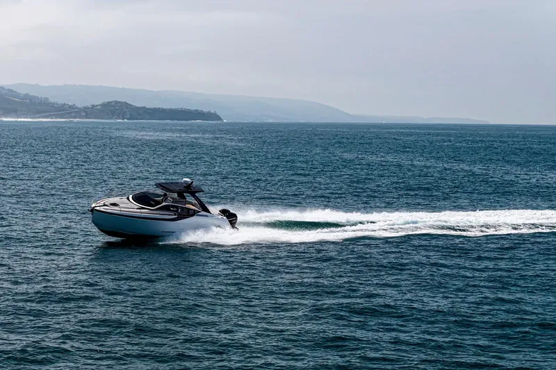 Slide: The Image of 2023 Fairline F//Line 33 Outboard cruising on open sea with scenic coastline backdrop. - 70