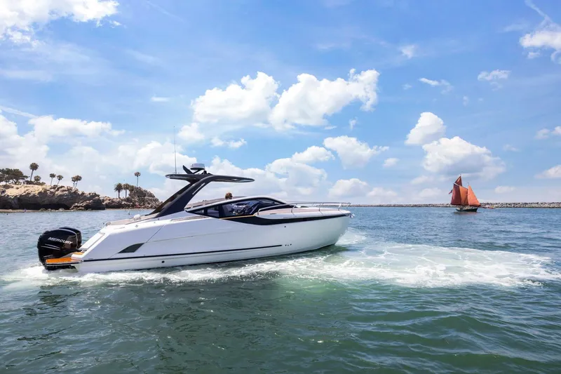 Slide: The Image of 2023 Fairline F//Line 33 Outboard cruising on a sunny day with a sailboat nearby. - 73