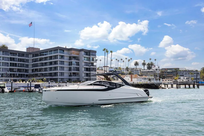 Slide: The Image of 2023 Fairline F//Line 33 Outboard yacht cruising near modern waterfront buildings. - 9