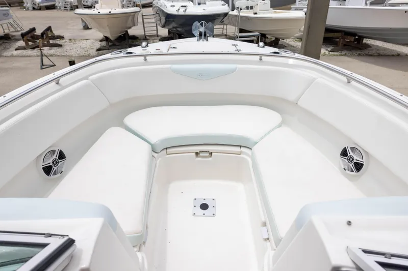 Slide: The Image of 2018 Robalo R247 Dual Console boat interior with white seating and speakers. - 11