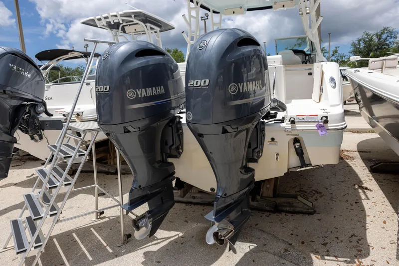 Slide: The Image of 2018 Robalo R247 Dual Console with twin Yamaha 200 engines, docked outdoors. - 3