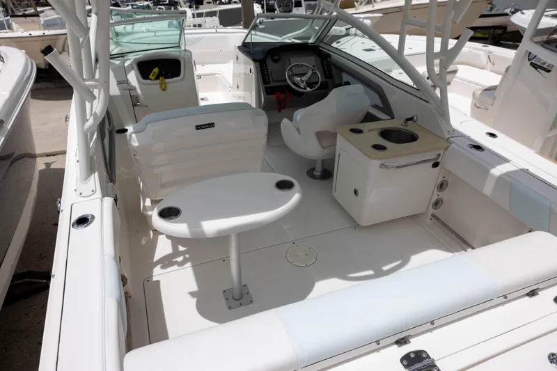 Slide: The Image of 2018 Robalo R247 Dual Console boat interior with seating, table, and helm. - 4