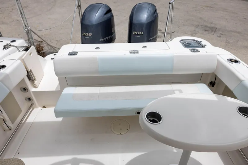 Slide: The Image of 2018 Robalo R247 Dual Console boat interior with seating and twin 200 horsepower engines. - 6