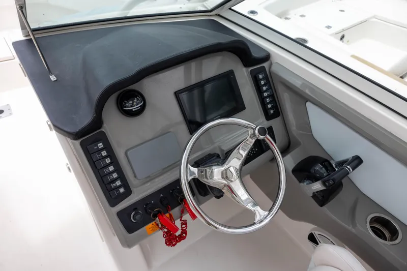 Slide: The Image of 2018 Robalo R247 Dual Console boat dashboard with steering wheel and control panel. - 7