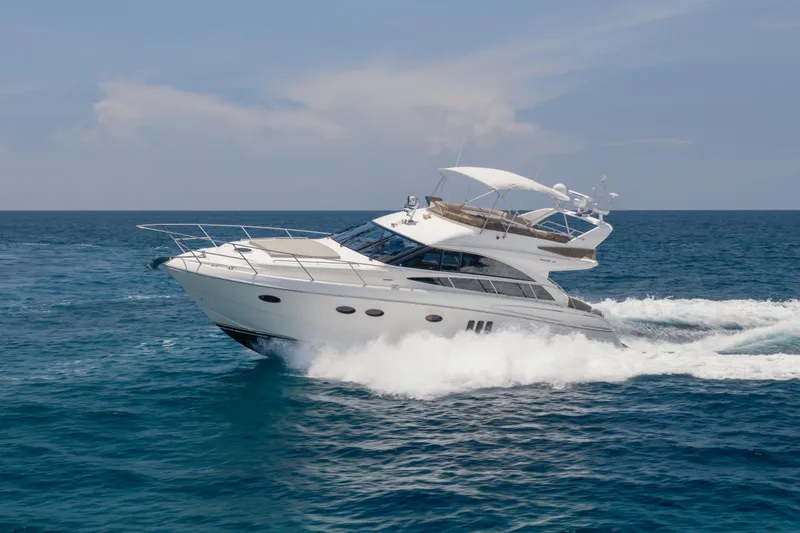Slide: The Image of 2009 Princess 54 Flybridge yacht cruising on open sea under clear skies. - 5