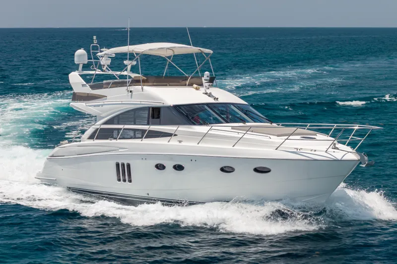 Slide: The Image of 2009 Princess 54 Flybridge yacht cruising on open sea, showcasing sleek design and luxury. - 11
