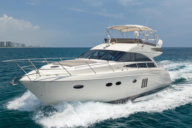 Slide: The Image of 2009 Princess 54 Flybridge yacht cruising on open water under clear skies. - 1