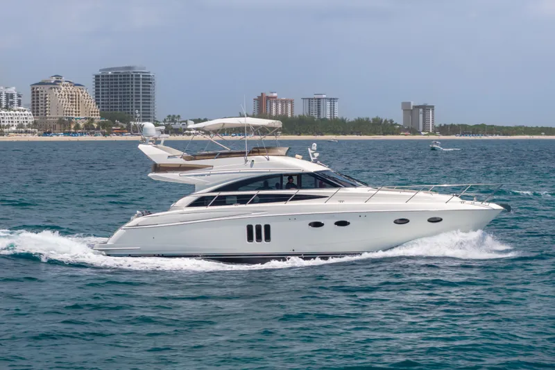 Slide: The Image of 2009 Princess 54 Flybridge yacht cruising near a coastal city skyline. - 6