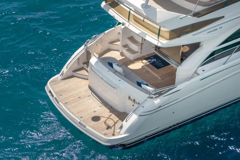 Slide: The Image of Luxurious 2009 Princess 54 Flybridge yacht on clear blue water, showcasing elegant deck design. - 23