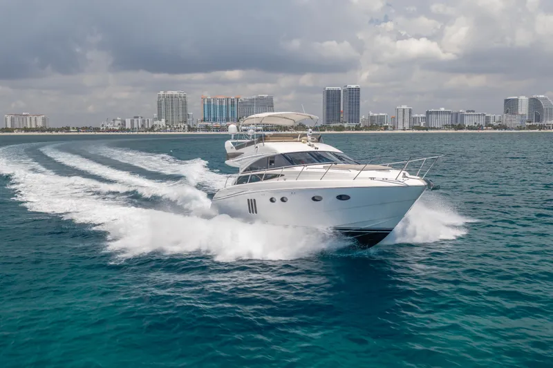 Slide: The Image of 2009 Princess 54 Flybridge yacht cruising near city skyline on a sunny day. - 13