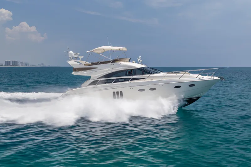 The Image of 2009 Princess 54 Flybridge yacht cruising on open sea under clear skies. - 0