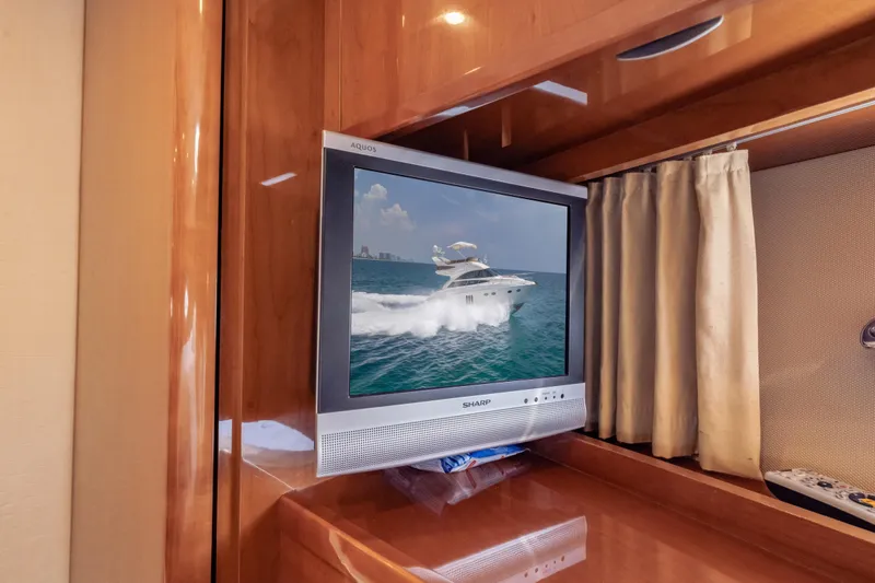 Slide: The Image of Sharp TV displaying a Princess 54 Flybridge yacht, 2009 model, in a wooden interior setting. - 59