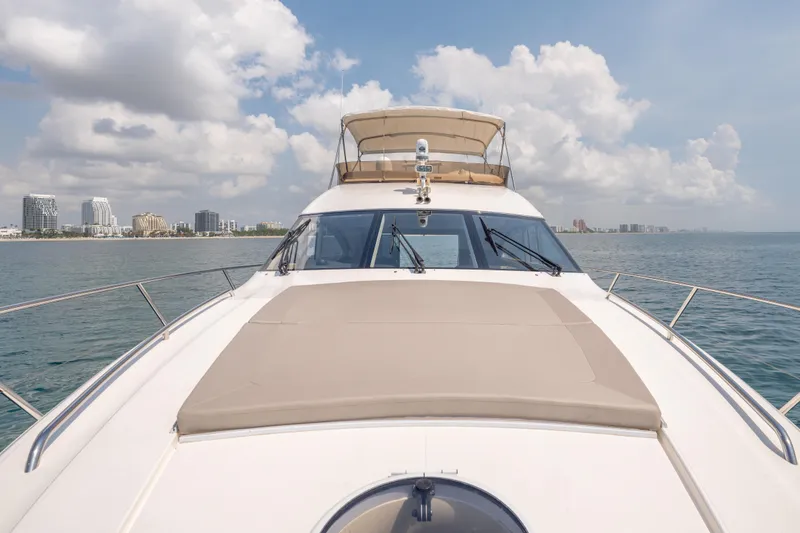 Slide: The Image of 2009 Princess 54 Flybridge yacht cruising near city skyline under cloudy sky. - 32