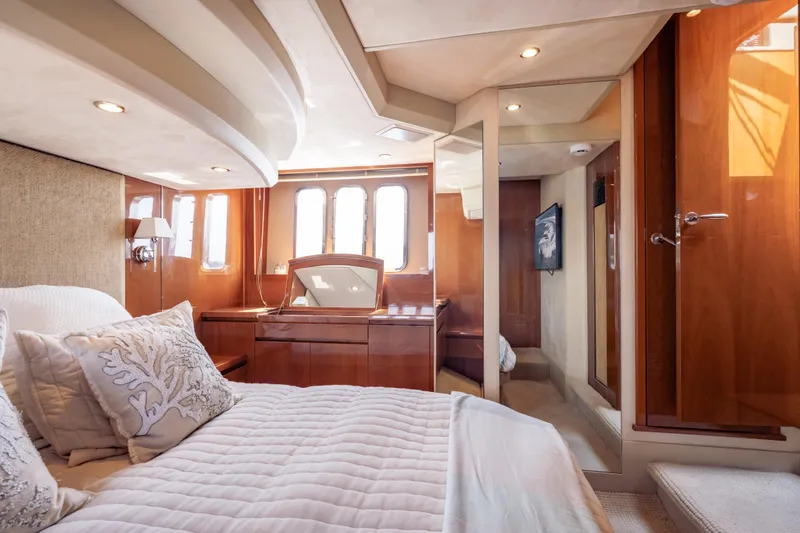 Slide: The Image of Luxurious 2009 Princess 54 Flybridge yacht bedroom with elegant wood finishes and plush bedding. - 54