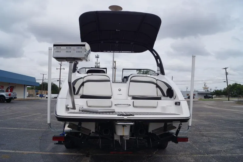 Slide: The Image of 2018 Yamaha Boats 242 Limited S, rear view in parking lot, overcast sky. - 13