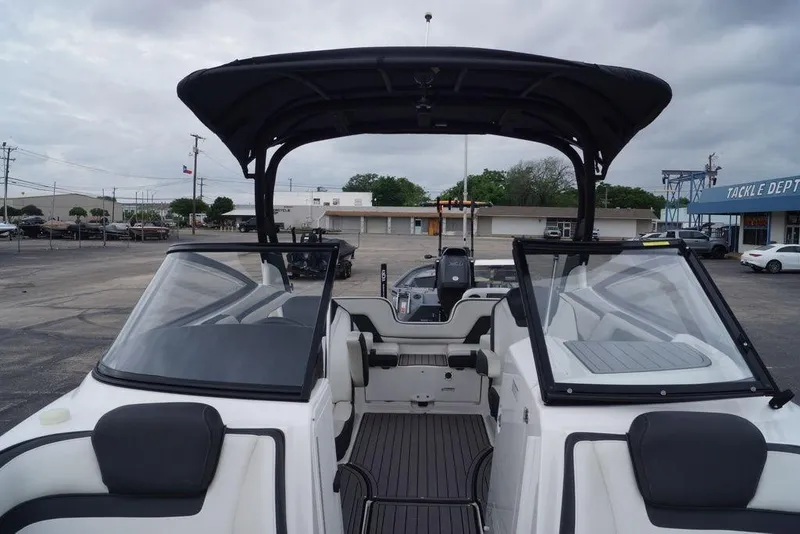 Slide: The Image of 2018 Yamaha Boats 242 Limited S with sleek interior and canopy, parked outdoors. - 25