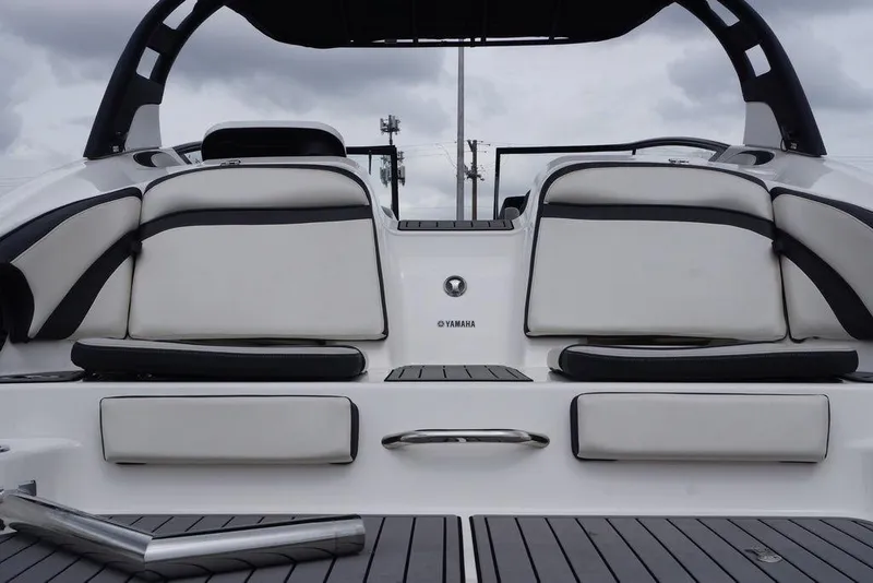 Slide: The Image of 2018 Yamaha Boats 242 Limited S, rear seating view, featuring sleek white and black upholstery. - 8
