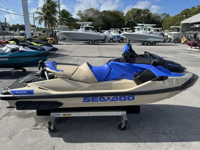 The Image of 2025 Sea-Doo Wake jet ski in parking lot, blue and beige design. - 1