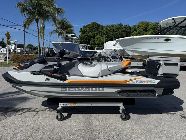 Slide: The Image of 2025 Sea-Doo FISH PRO jet ski on trailer, surrounded by boats and palm trees. - 6