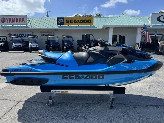 The Image of 2026 Sea-Doo RXT-X jet ski in vibrant blue on a trailer. - 1