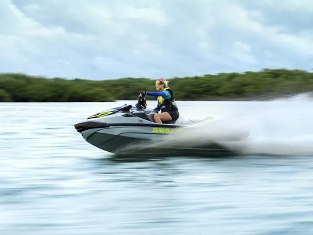 Slide: The Image of Person riding 2026 Sea-Doo RXT-X jet ski on open water. - 3