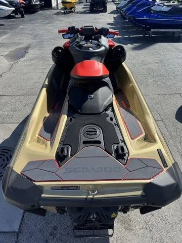 Slide: The Image of 2025 Sea-Doo RXP-X 325 jet ski, gold and black, parked outdoors. - 7