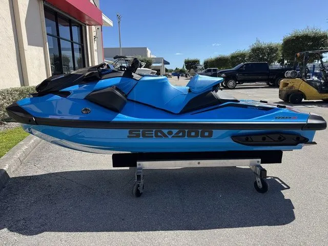 Slide: The Image of 2026 Sea-Doo RXP-X 325 in Gulfstream Blue on a parking lot. - 5
