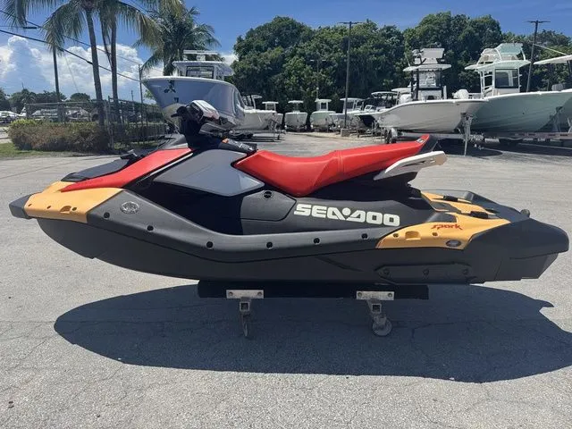 Slide: The Image of 2025 Sea-Doo Spark for 3, red and black, parked outdoors. - 6