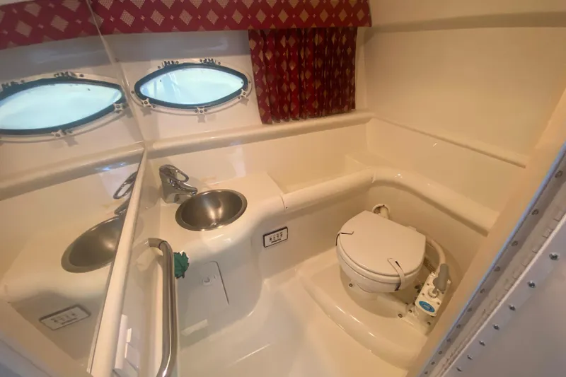 Slide: The Image of 2001 Formula 330 Sun Sport boat bathroom with sink, toilet, and porthole windows. - 20