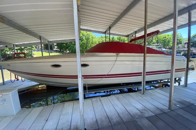 Slide: The Image of 2001 Formula 330 Sun Sport boat with red cover docked under a canopy. - 32
