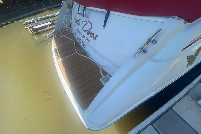 Slide: The Image of 2001 Formula 330 Sun Sport boat docked with wooden deck and red cover. - 4