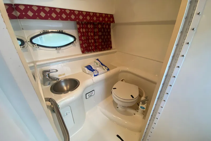 Slide: The Image of 2001 Formula 330 Sun Sport boat bathroom with sink, toilet, and porthole window. - 61