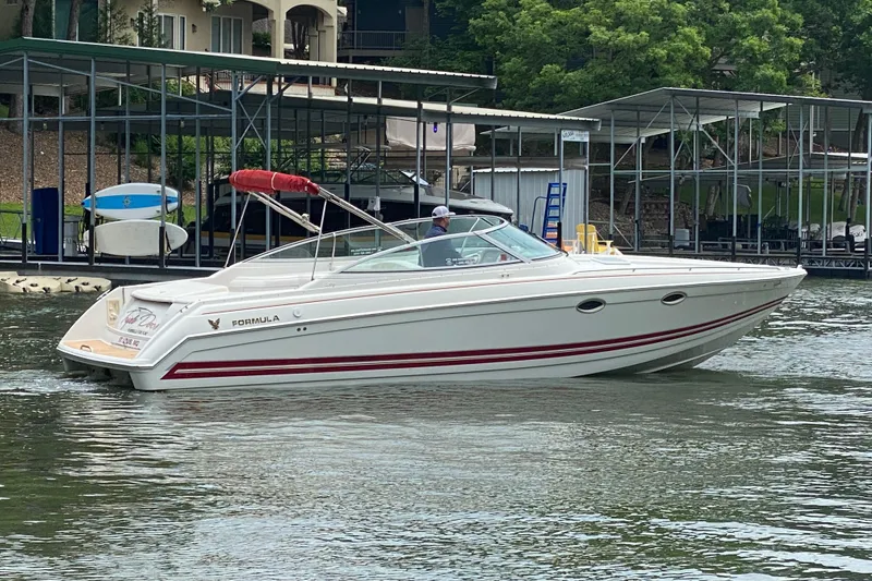 Slide: The Image of 2001 Formula 330 Sun Sport boat docked on a calm lake with lush greenery. - 2