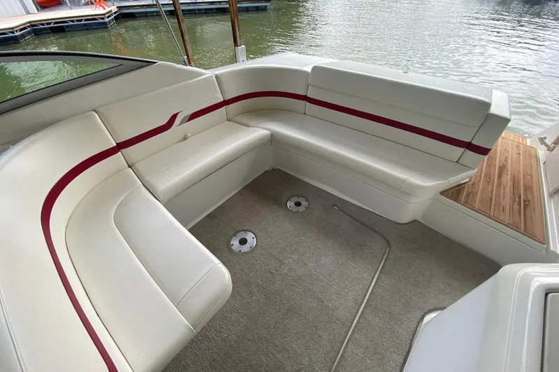 Slide: The Image of 2001 Formula 330 Sun Sport boat interior with white seating and red accents by the water. - 40