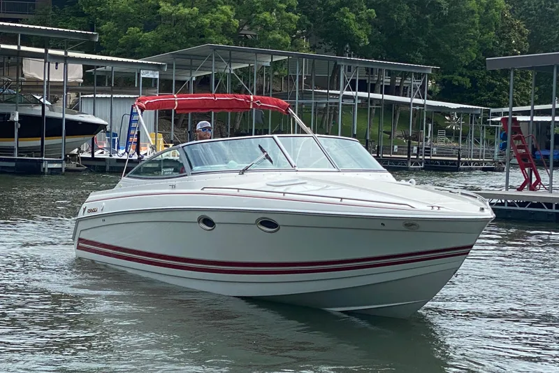 The Image of 2001 Formula 330 Sun Sport boat docked on a calm lake with lush greenery. - 1